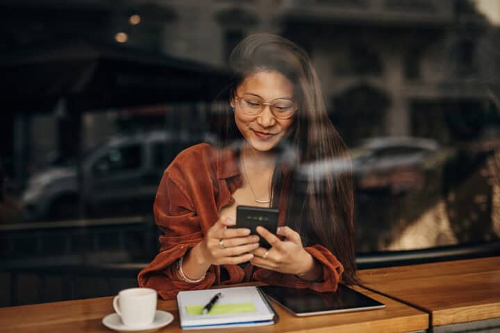 woman texting in cafe window