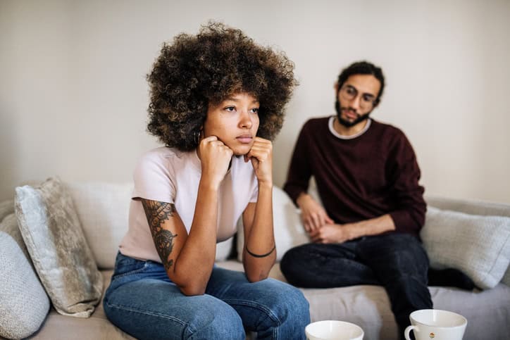 upset woman on couch with boyfriend