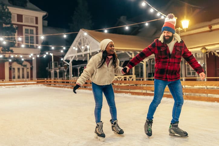 couple holding hands ice skating