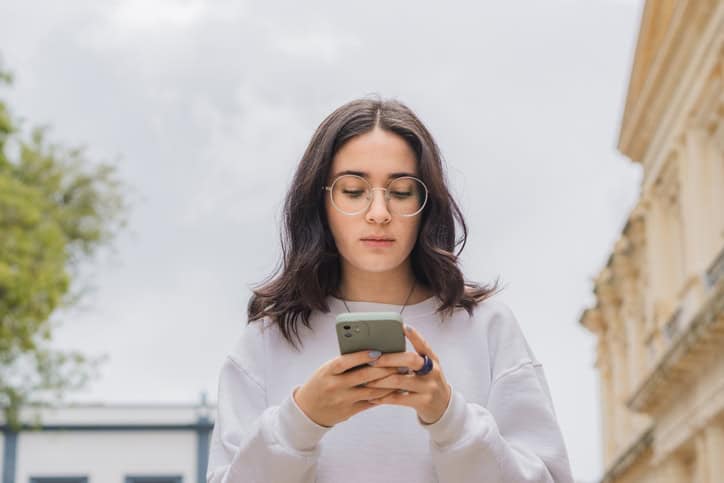 woman texting on phone outdoors