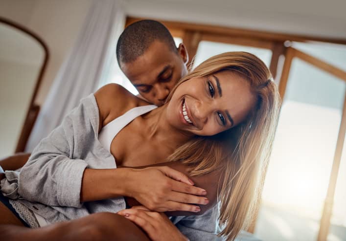 couple smiling and kissing in bed