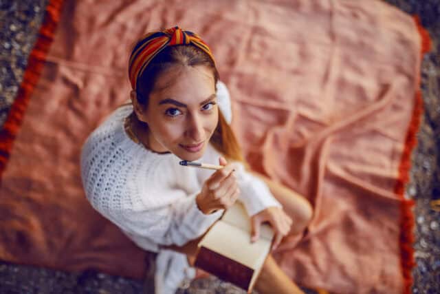 woman looking up from writing