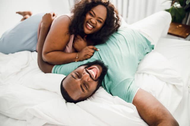 happy couple laughing in bed