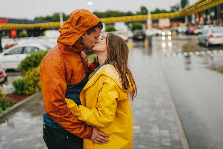 couple kissing at rainy gas station