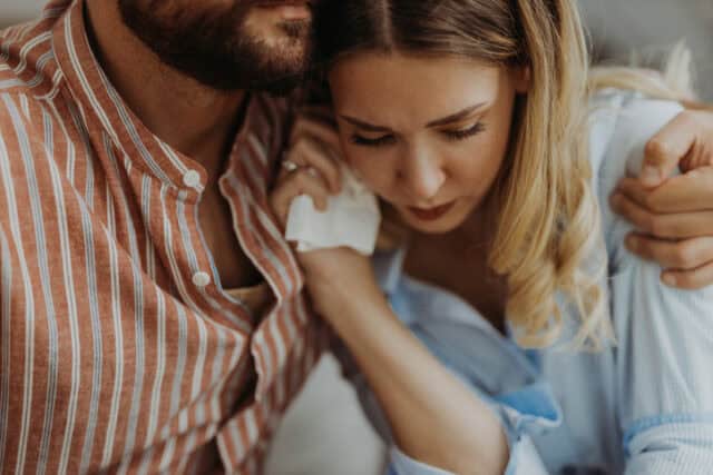 man comforting crying girlfriend