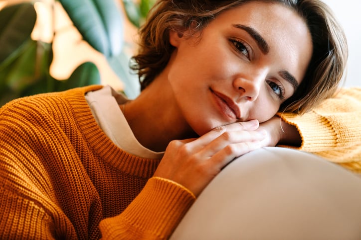 smiling brunette woman orange sweater