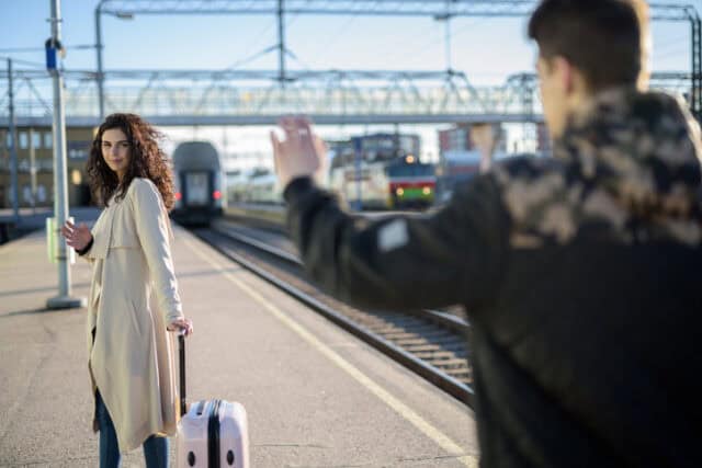 couple waving goodbye at train station