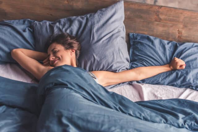 woman smiling and yawning in bed