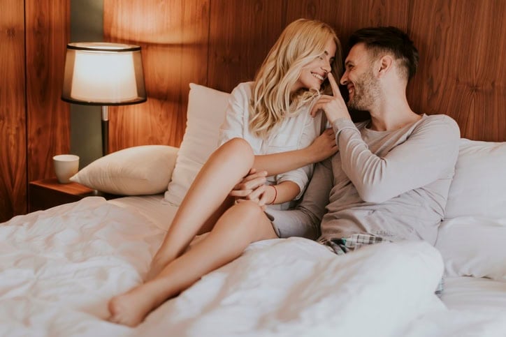 romantic couple in bed laughing