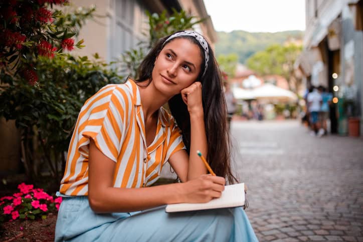 young woman writing outdoors