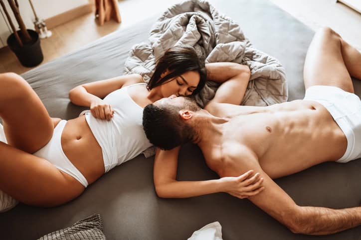 couple kissing in bed