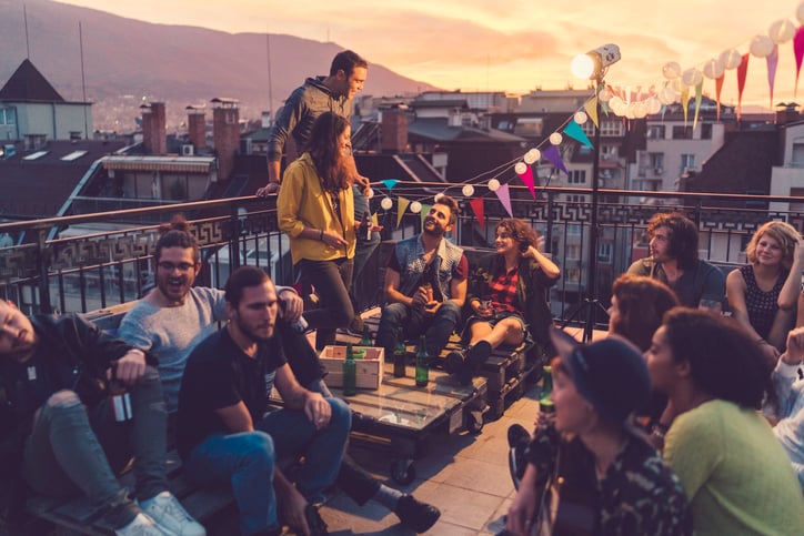 Friends having rooftop party at sunset.