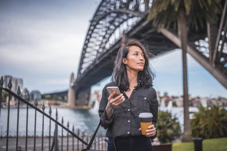woman texting outdoor with coffee