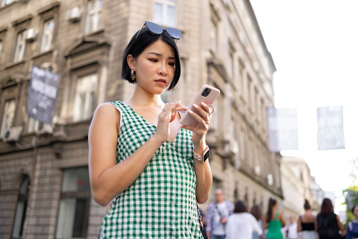 woman texting on city streets