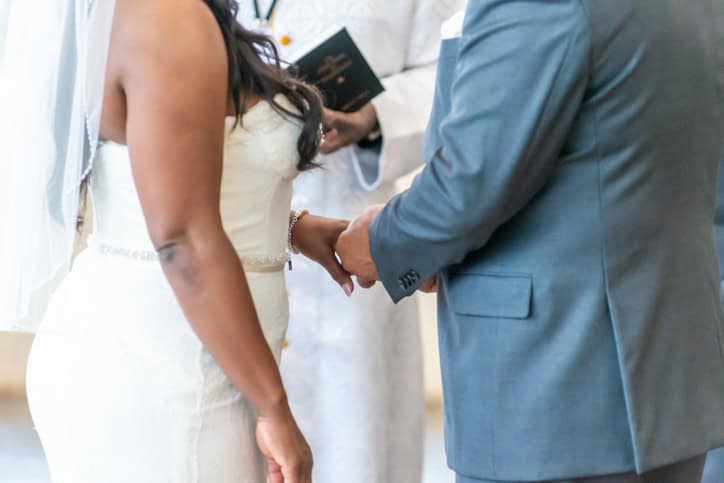 Couple exchanging rings at altar.