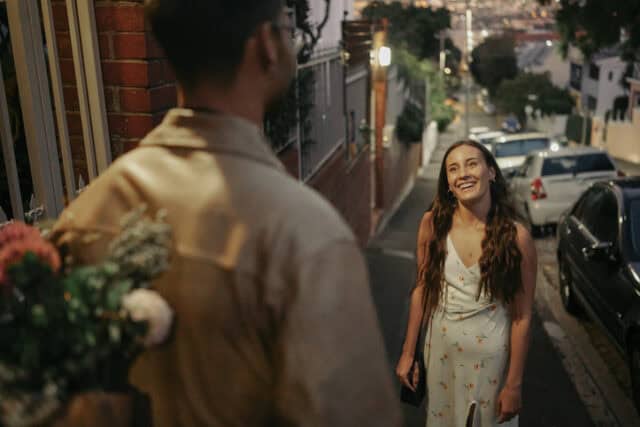 man surprising date with flowers at night