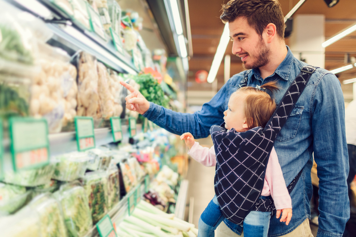Man with baby at grocery store.