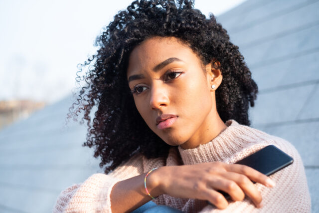 upset black woman with mobile phone