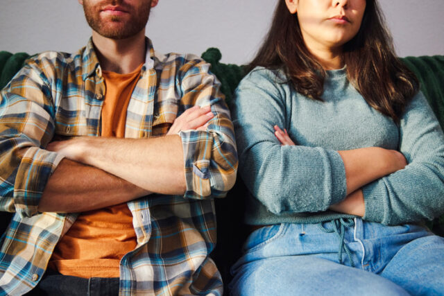 couple on couch arms crossed