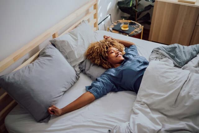 woman stretching in bed in morning