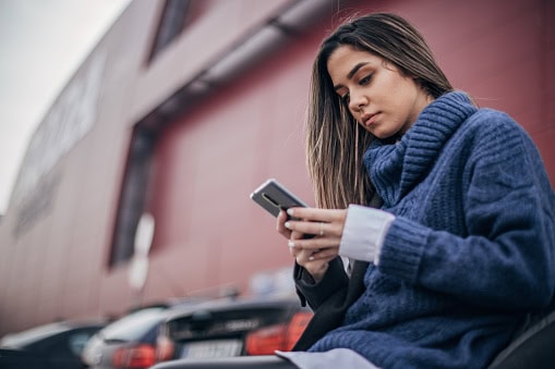 One beautiful young woman on the parking text messaging on the smart phone