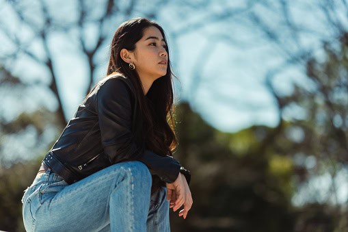 serious woman sitting on city street