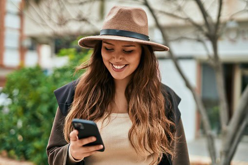 Young tourist woman using smartphone in the city.