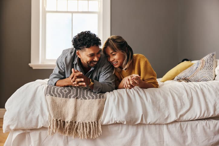 smiling couple laughing in bed