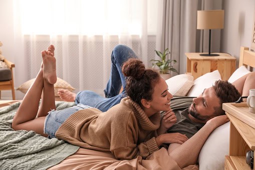 Lovely couple enjoying each other on bed at home