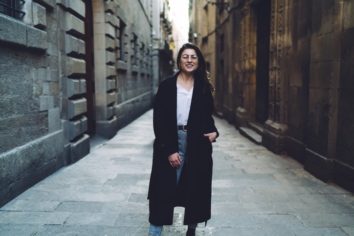 female tourist smiling in city alley