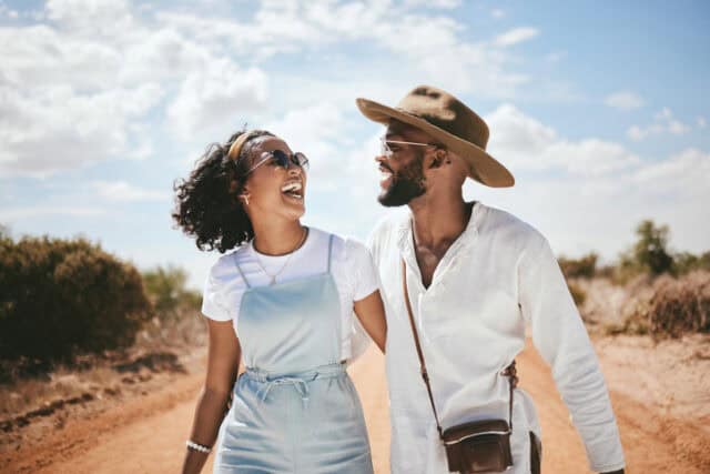 happy couple walking down dirt road