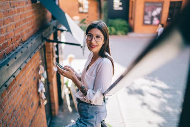 smiling texting woman on fire escape