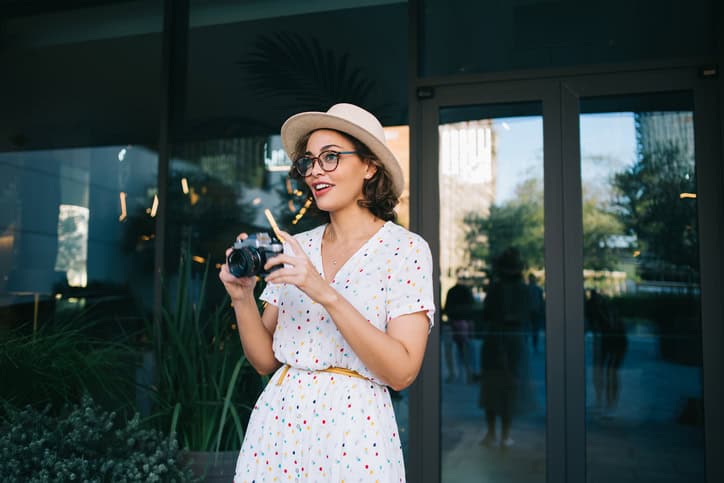 smiling woman in dress taking photos