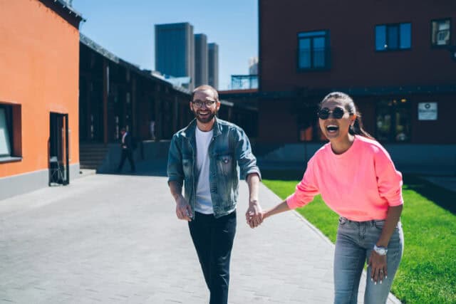 laughing couple holding hands outdoors
