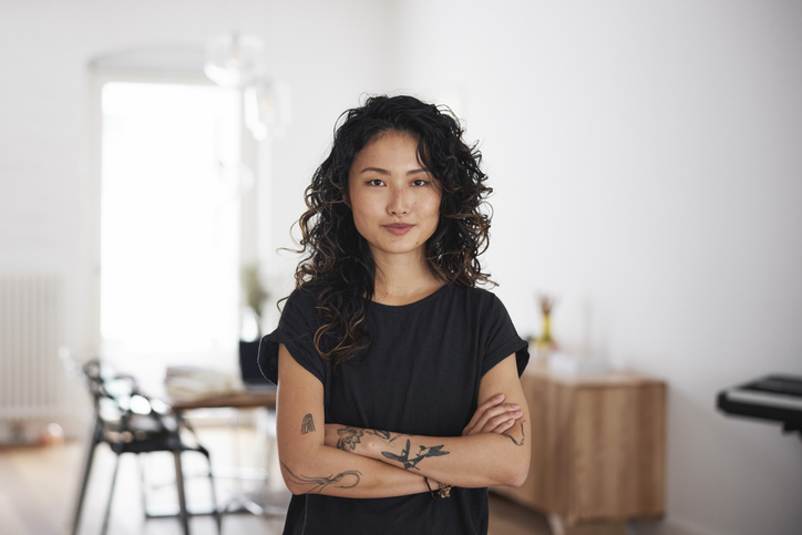 Woman with crossed arms in her home office.