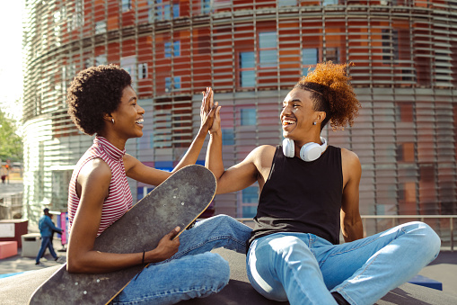 Cheerful African American young people in urban part of the city. High five gesture
