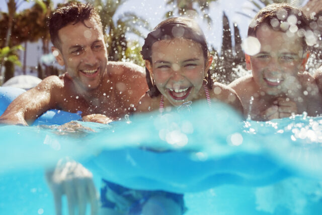 dad swimming on vacation with kids