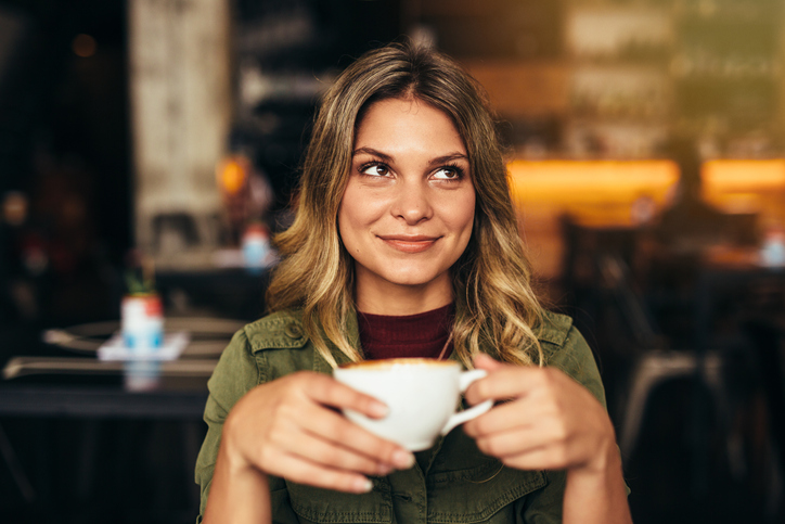 smiling woman with coffee at cafe
