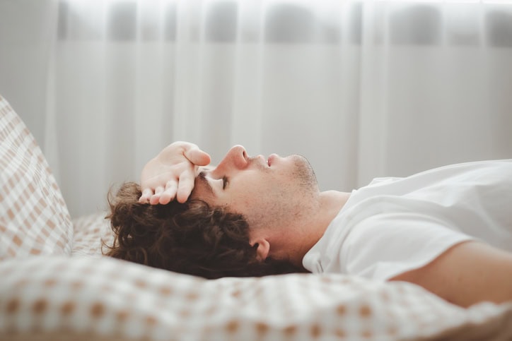Man laying in bed with a cold. 