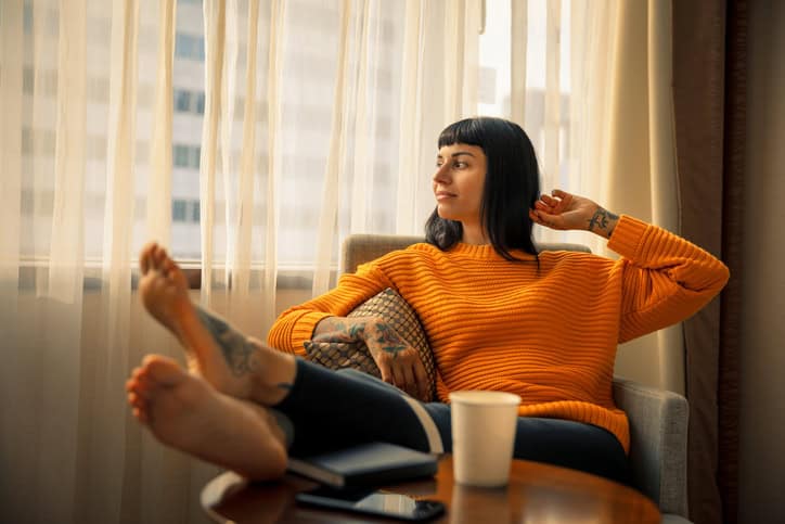 woman looking out apartment window