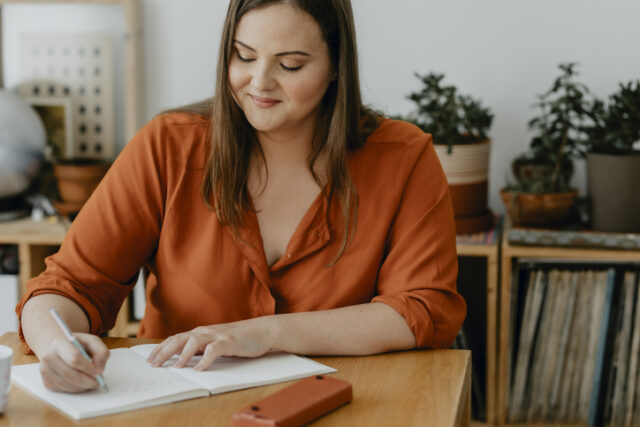smiling woman writing in journal