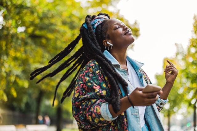 woman listening to headphones outside