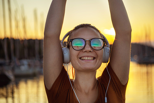 Happy woman listening to music on headphones.