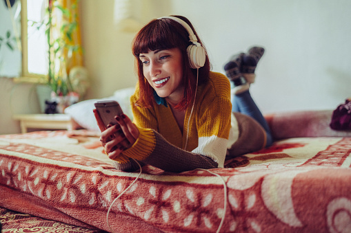 Relaxed girl on bed listening to music