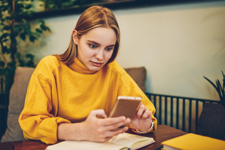Shocked woman reading her phone.