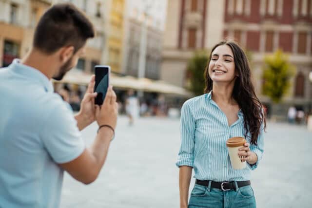 man taking woman's picture on vacation