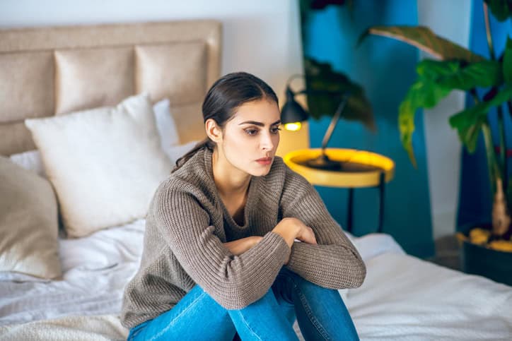 serious woman thoughtful in bed