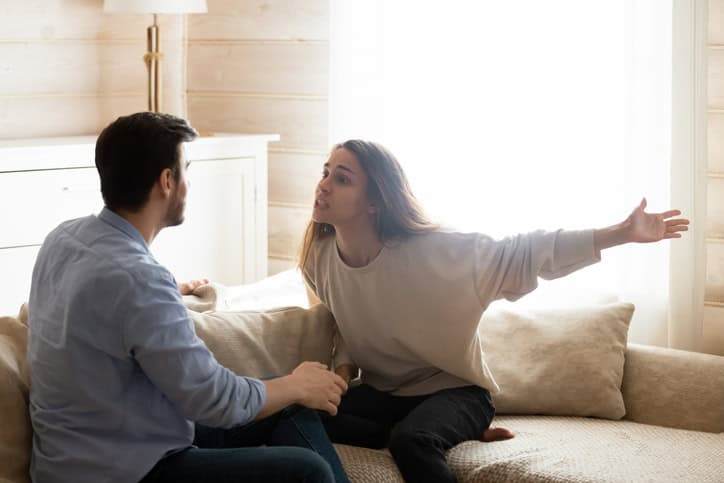 Upset couple fighting in living room.