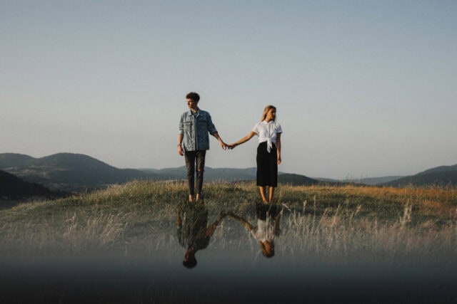 couple holding hands drifting apart