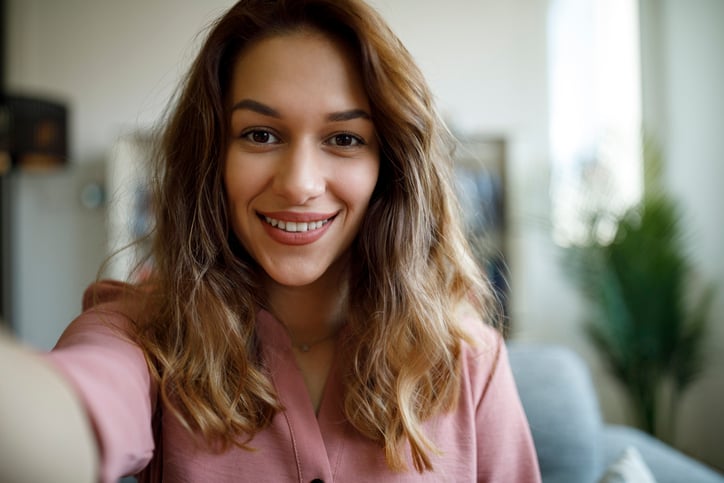 Woman smiling while taking a selfie.